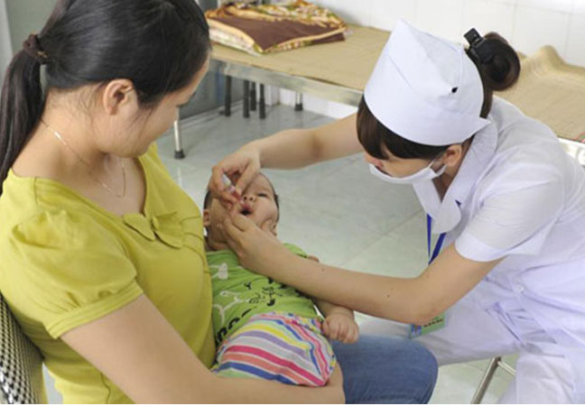 Cho trẻ uống vaccin phòng bệnh bại liệt.